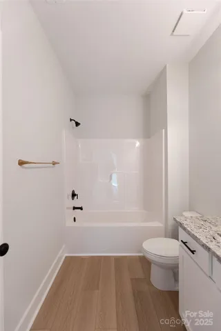 a bathroom with a granite countertop sink a toilet a mirror and shower