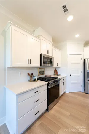 a kitchen with stainless steel appliances granite countertop a stove a sink and a refrigerator