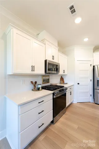 a kitchen with stainless steel appliances granite countertop a stove a sink and a refrigerator