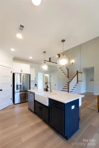 a large room with a large counter top a refrigerator and a sink