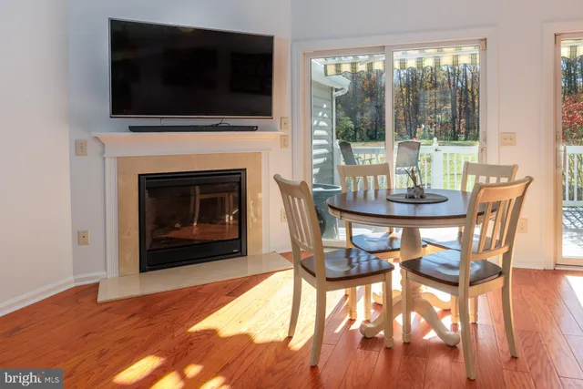 a dining room with furniture wooden floor fire place and an entrance