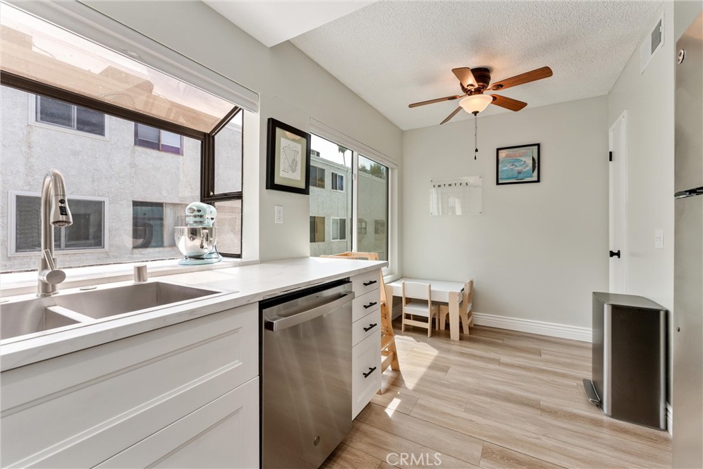 19431 Sherman Way, Unit 24 Reseda, CA 91335 - Photo 11 of 26 a kitchen with stainless steel appliances granite countertop a sink and dishwasher with wooden floor