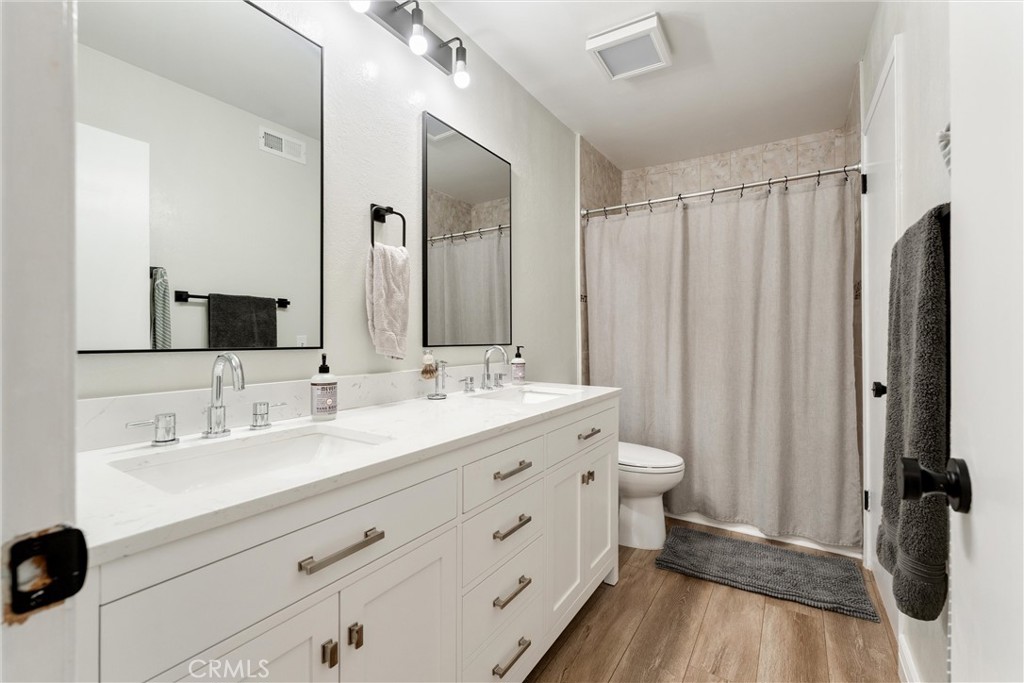 19431 Sherman Way, Unit 24 Reseda, CA 91335 - Photo 14 of 26 a bathroom with a double vanity sink a toilet and a mirror