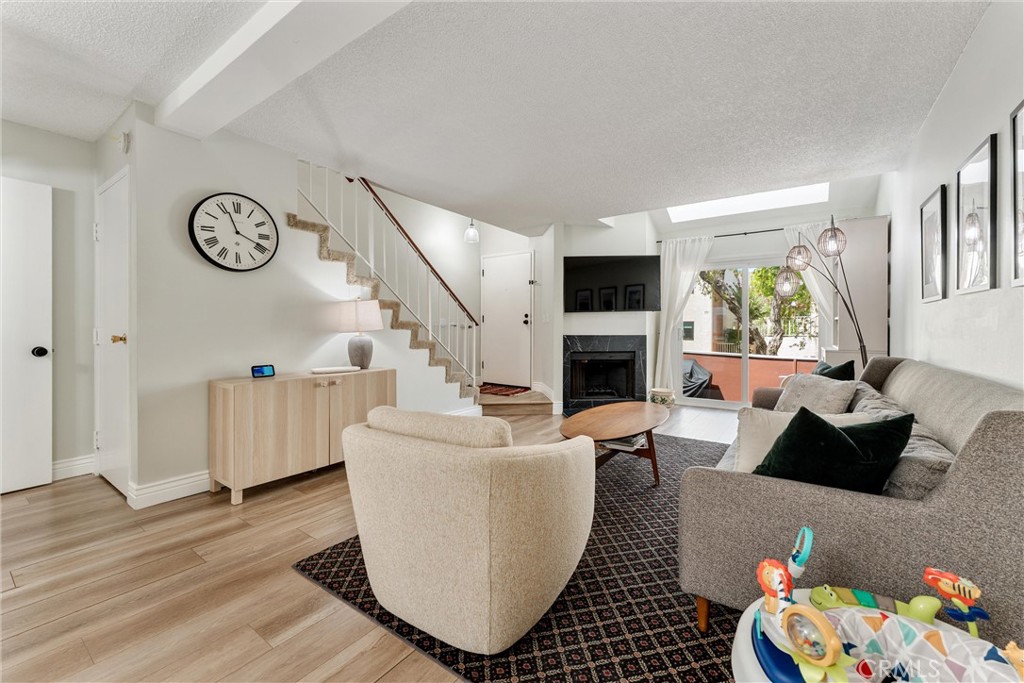 19431 Sherman Way, Unit 24 Reseda, CA 91335 - Photo 4 of 26 a living room with fireplace furniture and a window