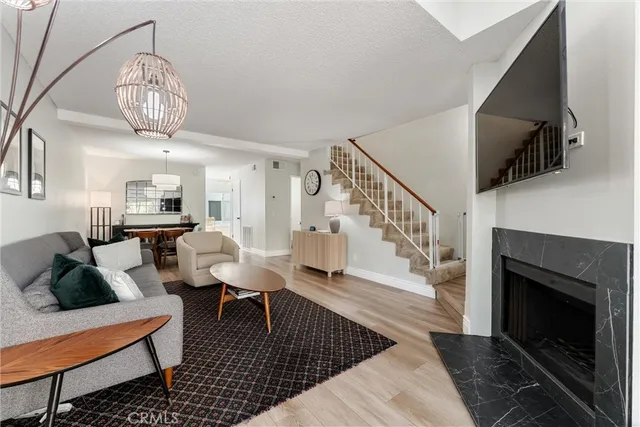a living room with furniture a chandelier and a fireplace