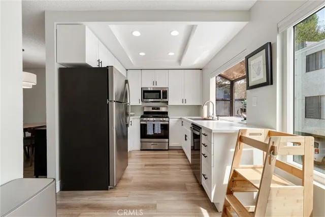 a kitchen with stainless steel appliances granite countertop a refrigerator and a stove top oven