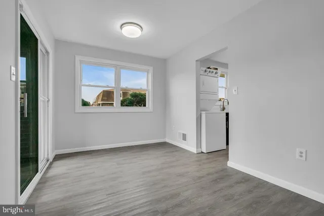 an empty room with window and wooden floor