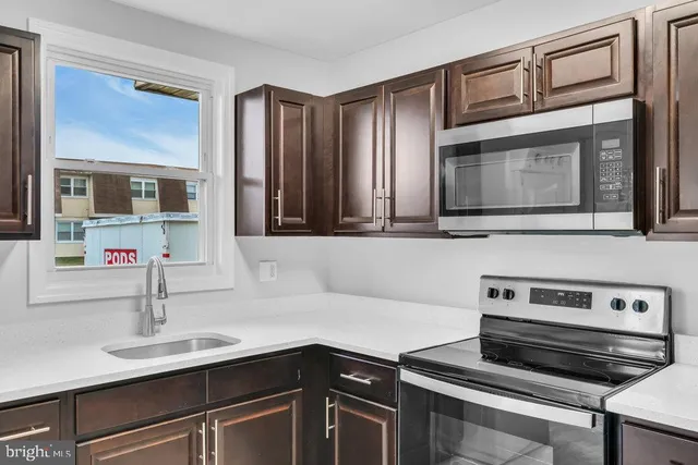 a kitchen with a sink stove and microwave