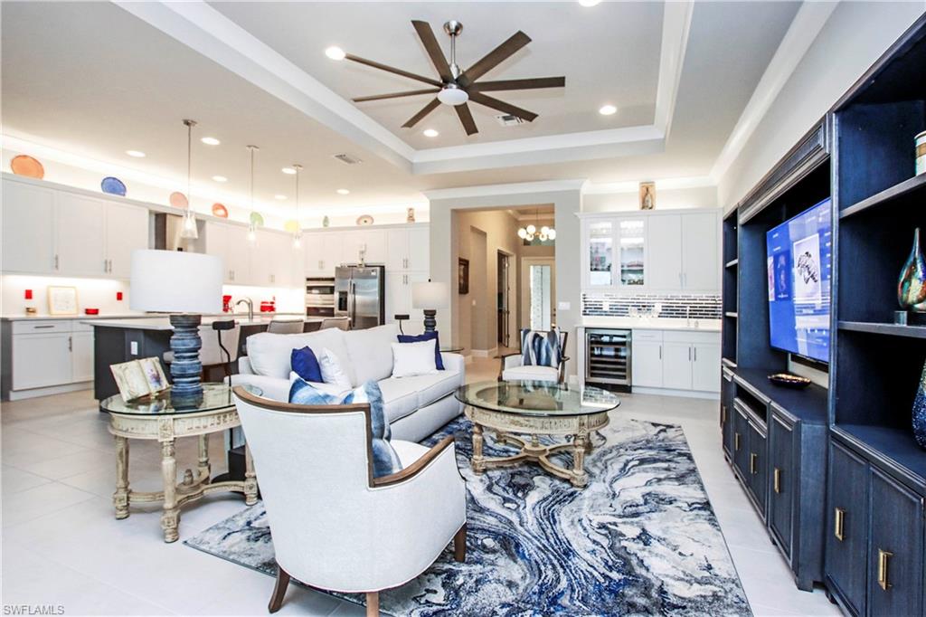 11857 Hydrangea Place Naples, FL 34120 - Photo 11 of 50 a living room with furniture a fireplace and kitchen view