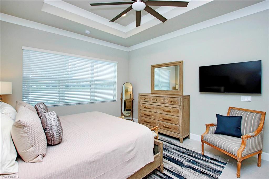 11857 Hydrangea Place Naples, FL 34120 - Photo 16 of 50 a bedroom with a bed and a flat screen tv