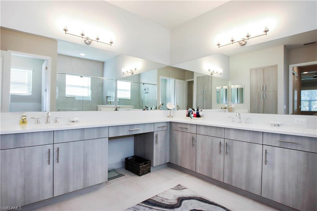 11857 Hydrangea Place Naples, FL 34120 - Photo 20 of 50 a bathroom with a double vanity sink and a mirror
