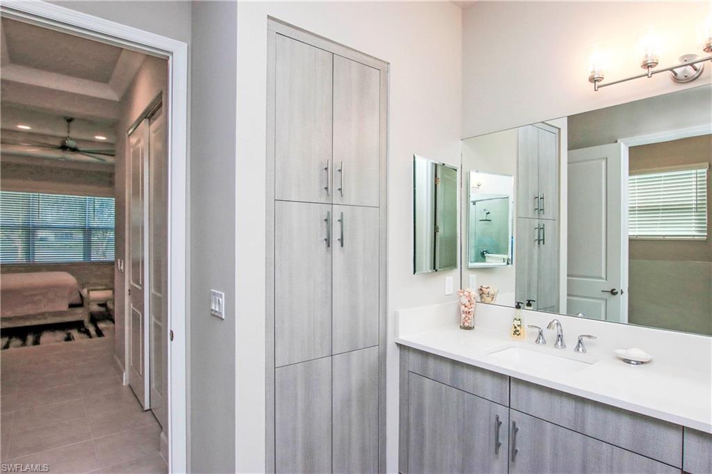 11857 Hydrangea Place Naples, FL 34120 - Photo 21 of 50 a en suite bathroom with a double vanity sink a mirror and a shower