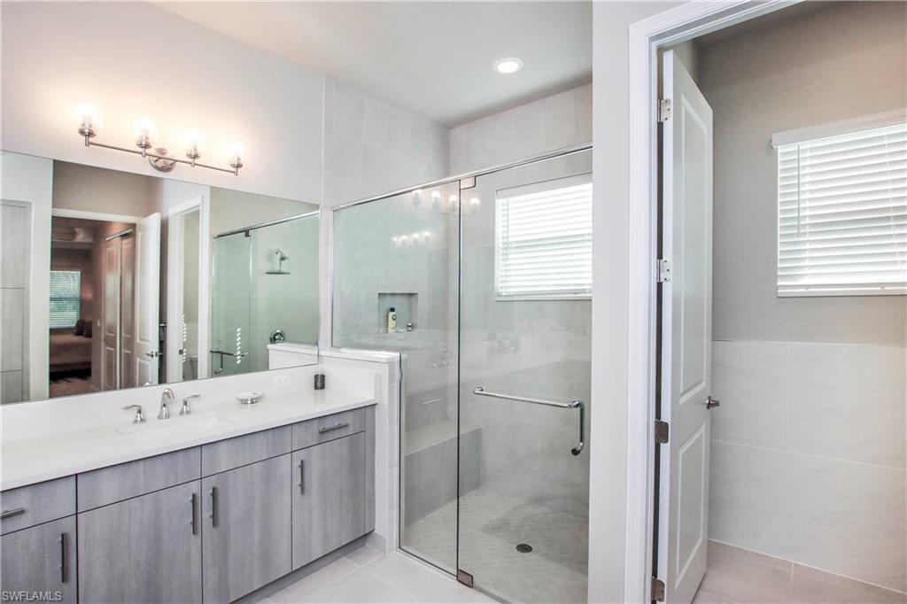 11857 Hydrangea Place Naples, FL 34120 - Photo 23 of 50 a bathroom with a double vanity sink mirror and shower