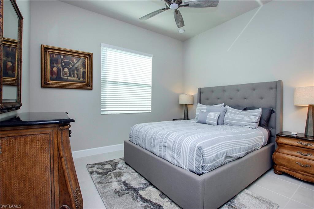 11857 Hydrangea Place Naples, FL 34120 - Photo 27 of 50 a large bed sitting in a bedroom next to a window