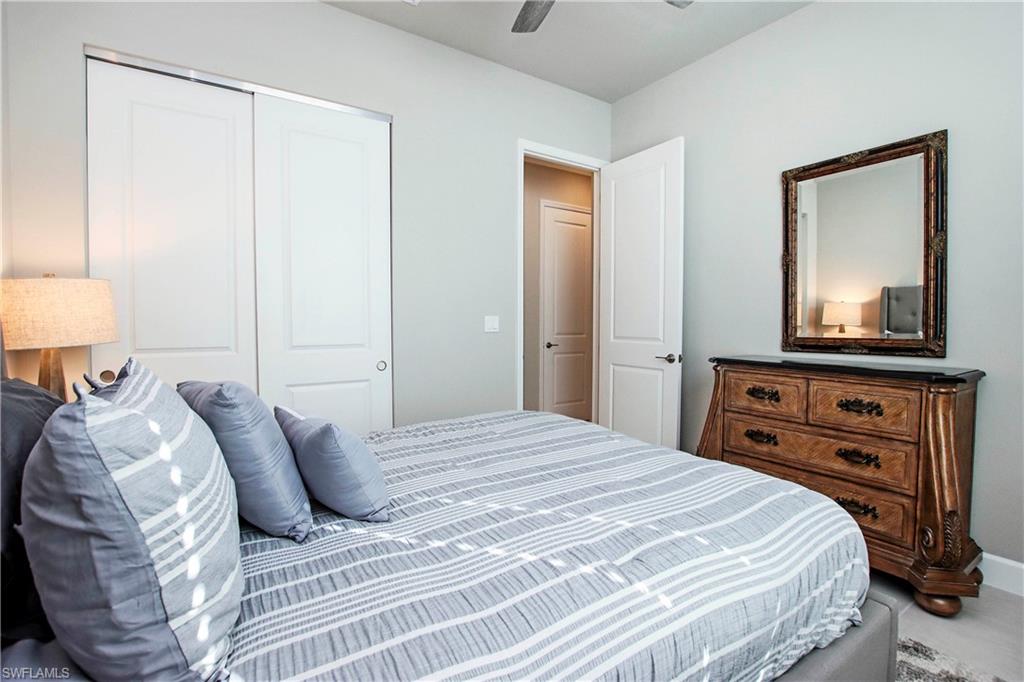 11857 Hydrangea Place Naples, FL 34120 - Photo 28 of 50 a bedroom with a bed and a mirror on dresser