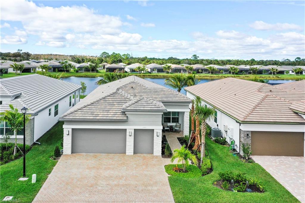 11857 Hydrangea Place Naples, FL 34120 - Photo 3 of 50 front view of a house with a yard