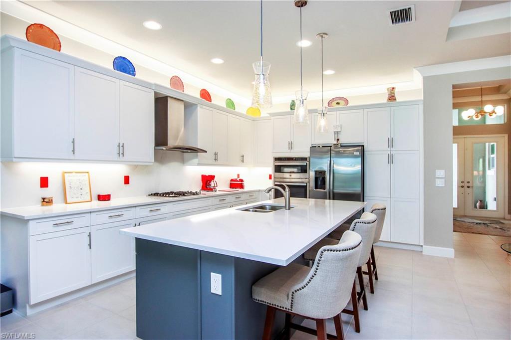 11857 Hydrangea Place Naples, FL 34120 - Photo 32 of 50 a kitchen that has a lot of cabinets in it and appliances