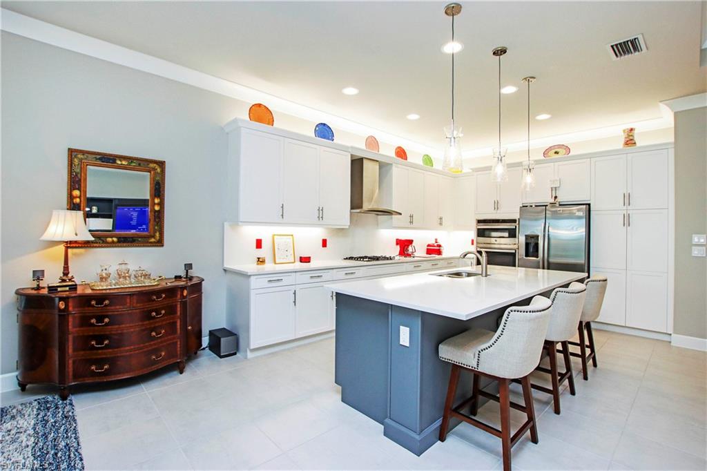 11857 Hydrangea Place Naples, FL 34120 - Photo 33 of 50 a kitchen that has a lot of cabinets and wooden floor