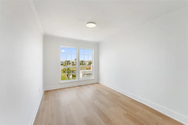 a view of a storage & utility room with window and wooden floor