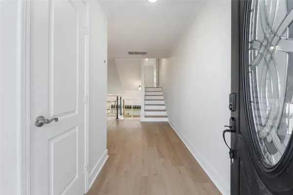 a view of a hallway with wooden floor and staircase