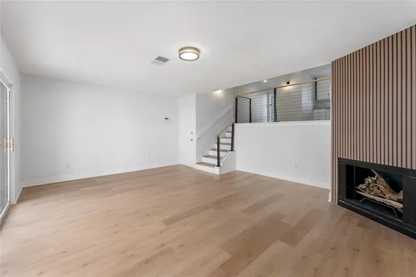 a view of a livingroom with wooden floor and a fireplace