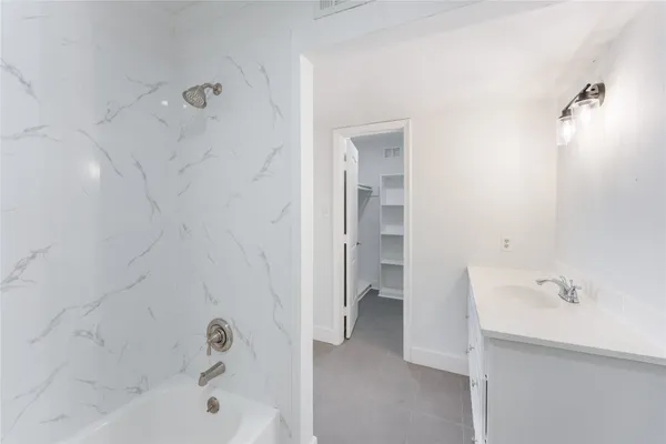 a bathroom with a tub sink shower and a mirror