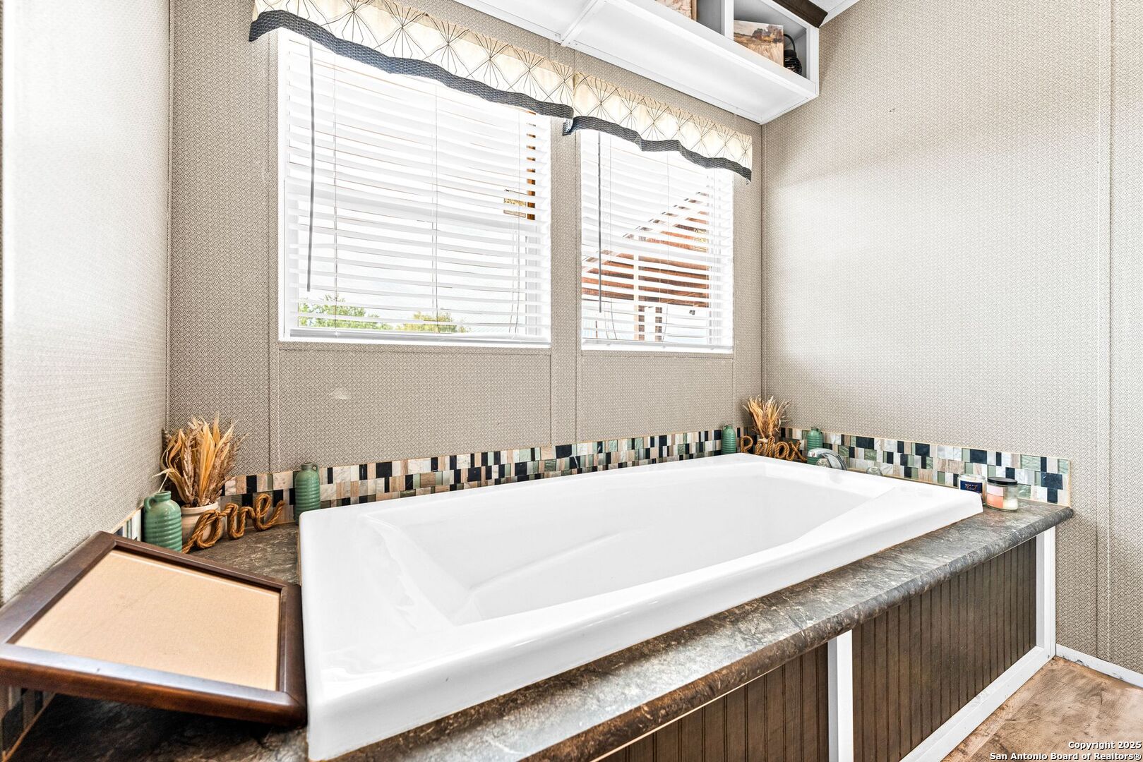 1979 County Road 651 Devine, TX 78016 - Photo 26 of 52 a bathroom with a tub a sink and a window