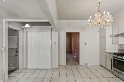 a view of an empty room with window and cabinet