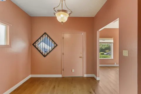 an empty room with wooden floor and window