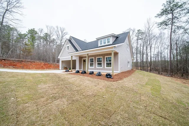 a view of a house with backyard and trees