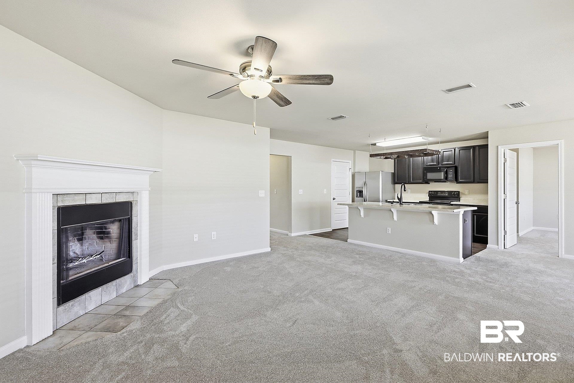 983 Summerton Drive Foley, AL 36535 - Photo 9 of 25 Unfurnished living room with light colored carpet, a tile fireplace, and ceiling fan