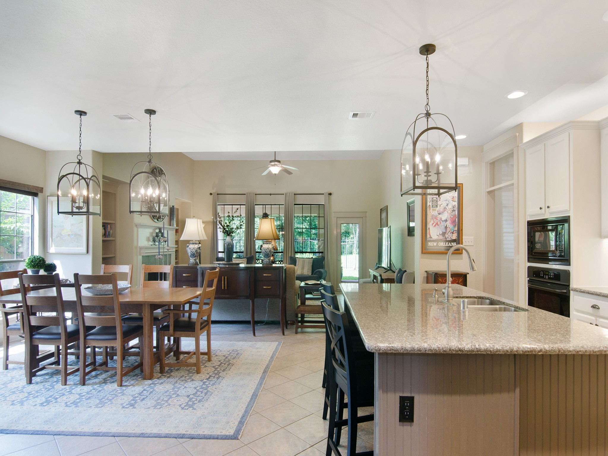 28323 Ryans Ridge Lane Spring, TX 77386 - Photo 14 of 45 This spacious casual dining area seamlessly connects the kitchen and family room, while coordinating designer light fixtures blend the rooms together and enhance the home's cohesive design.