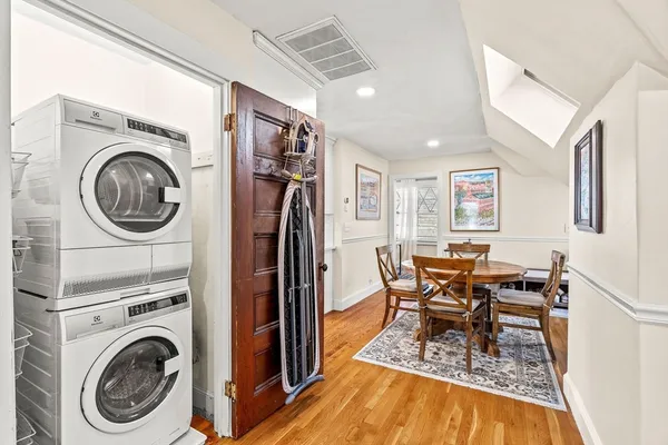 a view of a dining room with furniture a rug and wooden floor