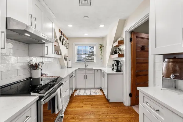 a kitchen with granite countertop a sink stainless steel appliances and cabinets
