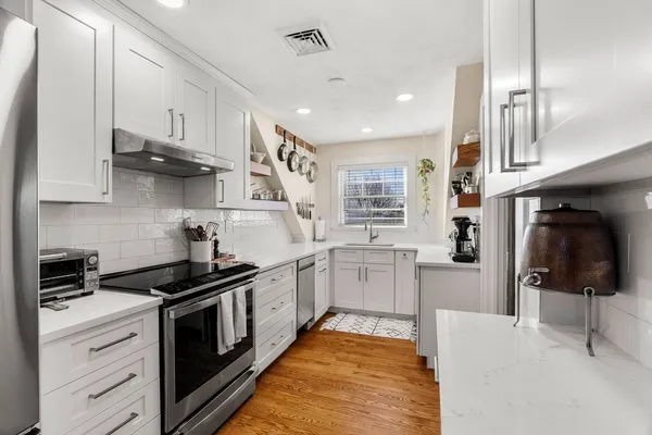 a kitchen with stainless steel appliances kitchen island granite countertop a stove a sink and a refrigerator