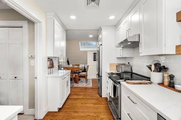 a kitchen with white cabinets and stainless steel appliances