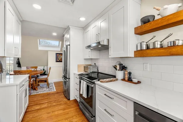 a kitchen with stainless steel appliances a sink a stove and a wooden floors