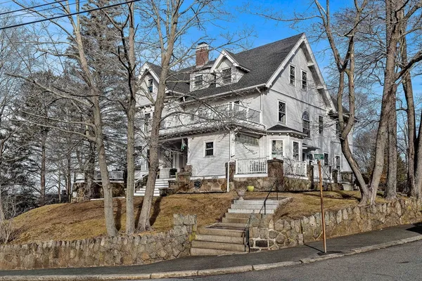 a view of a white house with large tree and outdoor space