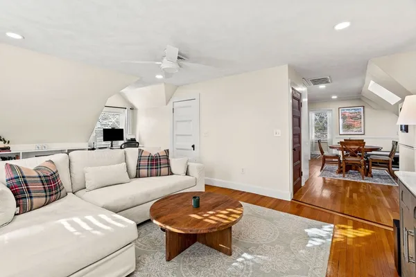a living room with furniture and a wooden floor