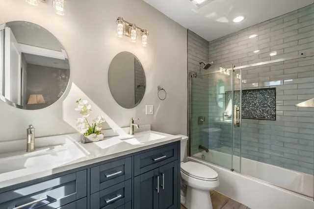 a bathroom with a double vanity sink toilet and a mirror