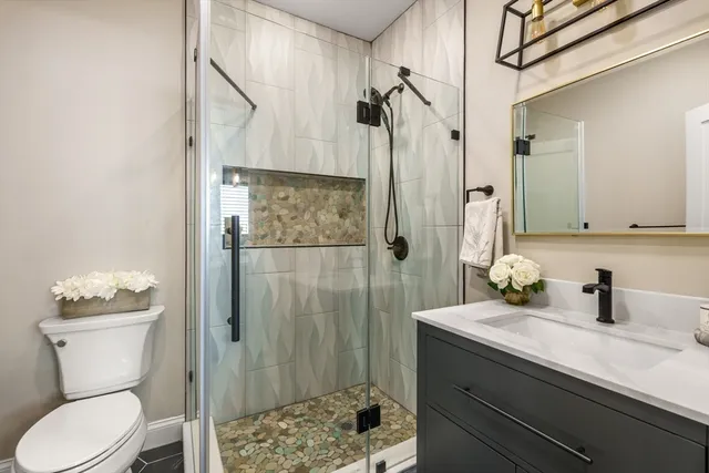 a bathroom with a sink a toilet and shower