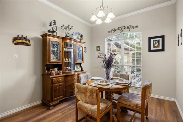 a view of a dining room with furniture wooden floor and chandelier