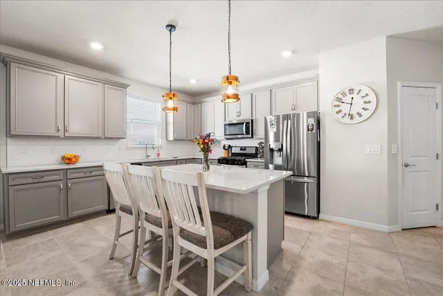 a kitchen with a refrigerator a stove a sink dishwasher with a dining table and chairs