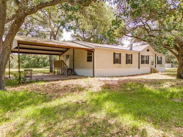 a backyard of a house with table and chairs