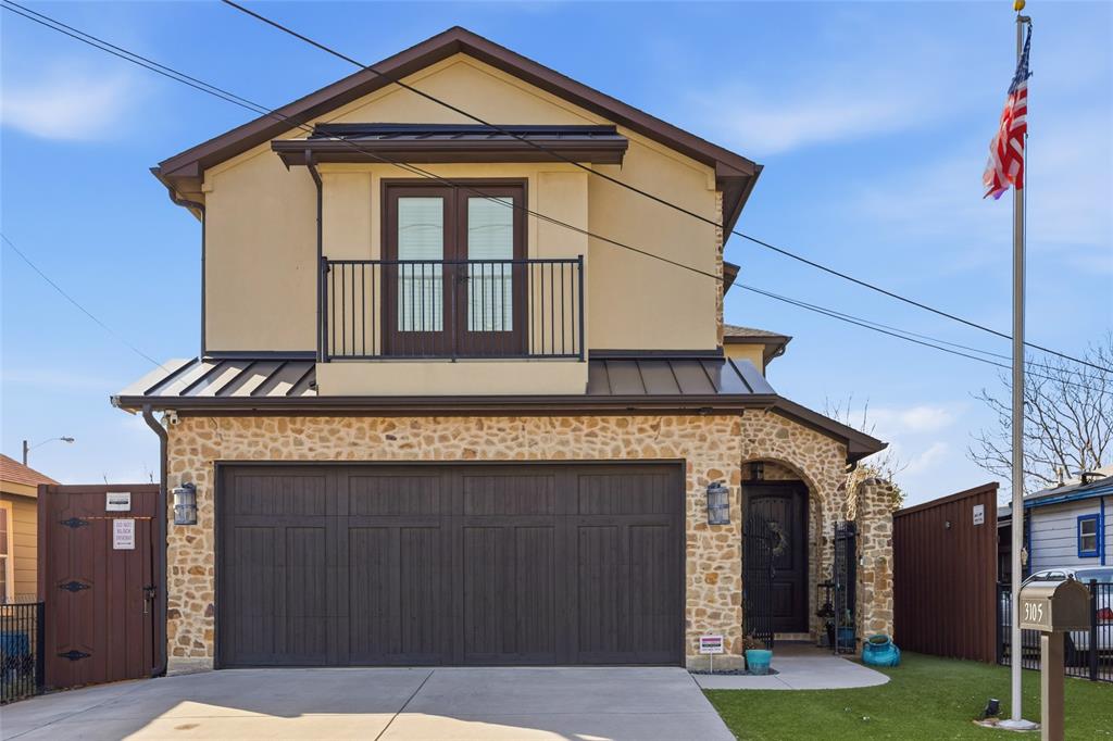 3105 Pastor Street Dallas, TX 75212 - Photo 10 of 28 View of front facade with a standing seam roof, stone siding, an attached garage, concrete driveway, and a balcony. Stone one stucco combination, the home has been encapsulated for maximum efficiency