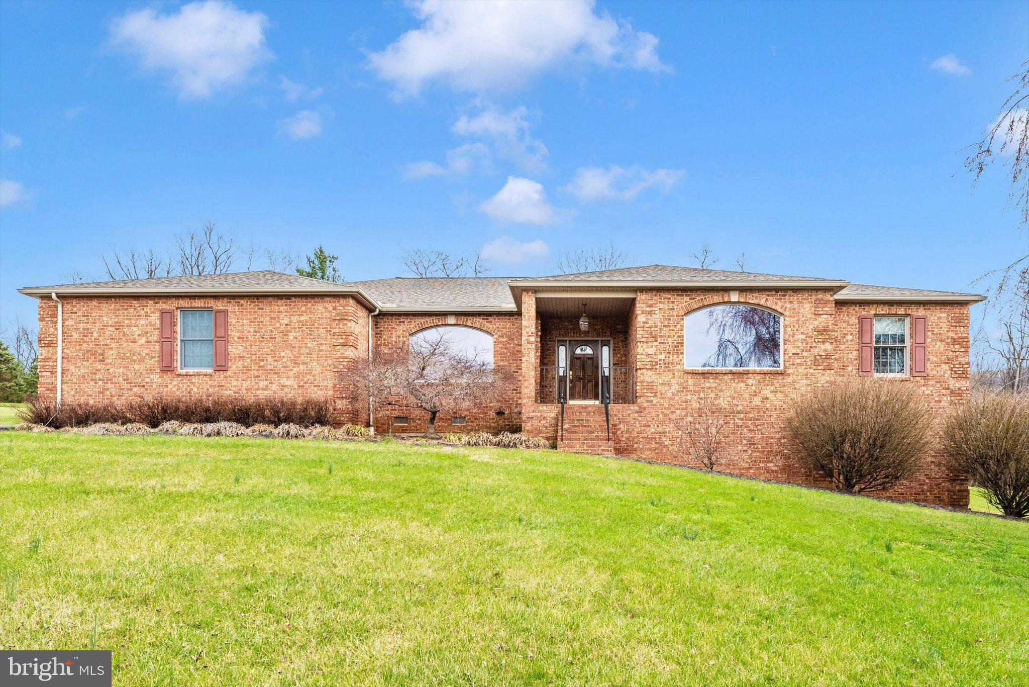 Charming brick home on lush green lawn.