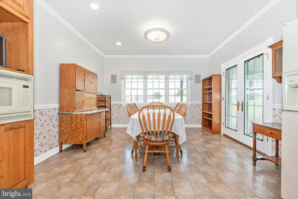 a living room with furniture a dining table and a floor to ceiling window