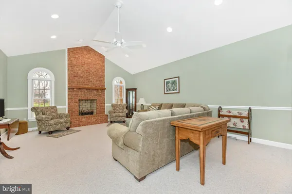 a living room with furniture a fireplace and a chandelier