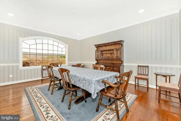 a view of a a dining room with furniture window and wooden floor