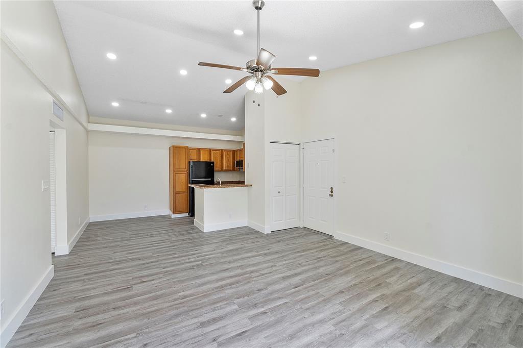 a view of a livingroom with a kitchen counter top space and wooden floor